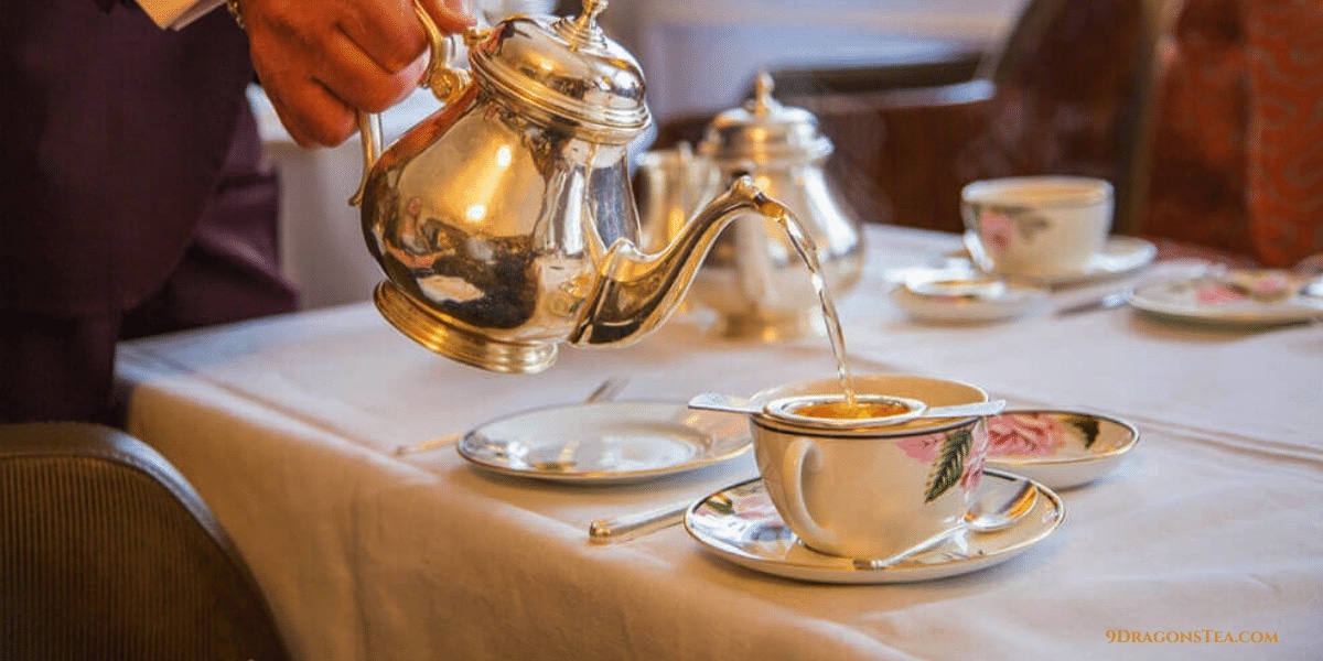 english tea pot pouring tea with a strainer