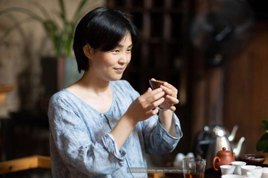 Wuyishan culture Chinese tea rituals gong fu cha tea tasting Duer Zhang a lady holding a cup with tea set teacups teapot Wuyishan culture Chinese tea rituals gong fu cha tea tasting Duer Zhang a lady holding a cup with tea set teacups teapot
